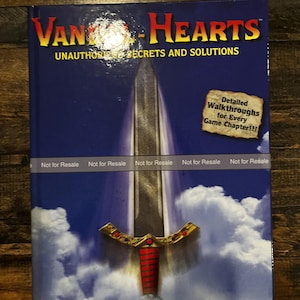 May include: A book titled "Van Hearts: Unauthorized Secrets and Solutions" with a sword illustration on the cover. The cover is blue with white clouds and gold and red accents. The book promises detailed walkthroughs for every game chapter.