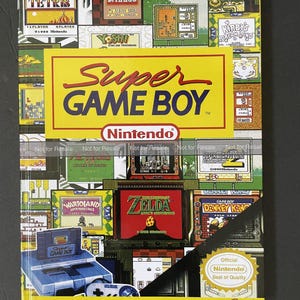 May include: A yellow and black book cover with the title "Super Game Boy" and the Nintendo logo. The cover features a collage of colorful video game cartridges and screenshots, including Tetris, Dr. Mario, Yoshi, Kirby's Dream Land, and The Legend of Zelda: A Link to the Past. The book is a guide to the colorful side of Game Boy.