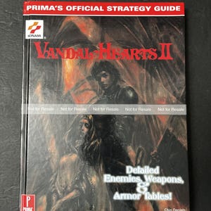 May include: A Prima's Official Strategy Guide for Vandal Hearts II. The cover features a dark, illustrated scene with figures and the game's title in red. The guide includes detailed enemy, weapon, and armor tables. The Konami logo is visible.