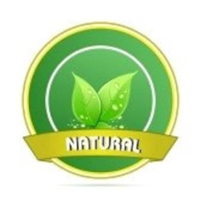 Op de afbeelding: Een cirkelvormig groen en geel embleem met het woord "NATURAL" in het wit. Het embleem toont twee groene bladeren met waterdruppels in een witte cirkel.