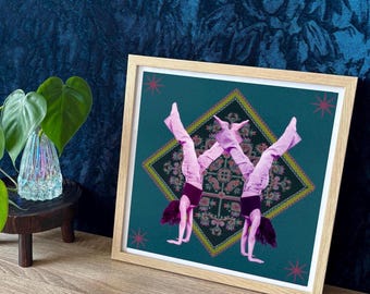Op de afbeelding: Twee mensen in roze broeken doen een handstand op een kleurrijk, gepatroneerd tapijt. Het tapijt is ingelijst in een houten lijst met een teal achtergrond.