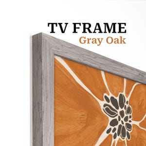 Puede incluir: Un marco de TV de roble gris rodea una pintura floral abstracta en tonos naranja, negro y blanco. El marco tiene un aspecto de veta de madera texturizada. El texto "TV FRAME" y "Gray Oak" se muestra en la imagen.