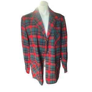 May include: A red, green, and navy plaid blazer with a notched collar and three brown buttons. The blazer has two front pockets and is displayed on a white mannequin. The plaid pattern includes yellow accent lines.