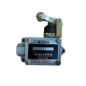May include: A silver micro switch with a black lever and a gold roller. The switch has the text "MICRO" and "MICRO SWITCH" printed on it. The text "BZFZ-3AN2" is also printed on the switch.