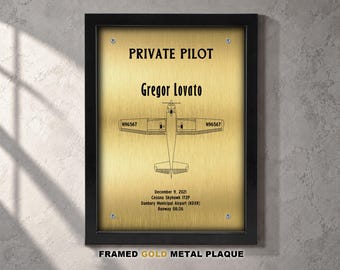 Peut inclure: Une plaque en métal doré encadrée présentant un dessin au trait noir d'un avion Cessna Skyhawk 172P. Le texte indique PRIVATE PILOT, Gregor Lovato, N96567, December 9, 2021, Cessna Skyhawk 172P, Danbury Municipal Airport (KDXR) et Runway 08/26.
