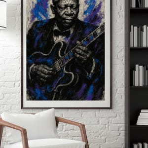 May include: Framed art print of a man playing a guitar, rendered in a blue, black, and white color palette. The artwork features a portrait of a musician in a suit and bow tie, holding a blue guitar. The background has blue and purple brushstrokes.