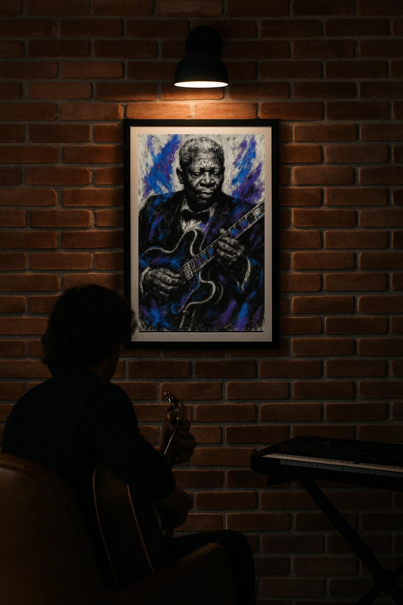 May include: A framed portrait of B.B. King playing a guitar hangs on a brick wall. The artwork features a blue and purple color palette. A person is seen in the foreground playing a guitar, with a keyboard in the background.