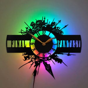 May include: A black wall clock crafted from a vinyl record featuring the text FINAL FANTASY. The design includes intricate silhouettes of characters and weapons, illuminated by a vibrant, multi-colored LED light ring behind the clock face.