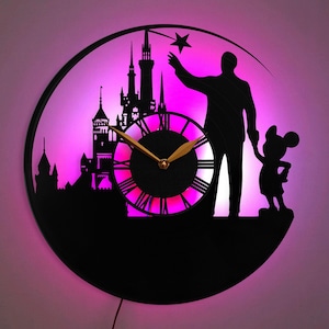 May include: A black vinyl record clock with a silhouette of Mickey Mouse and a character from Disney World. The clock face is illuminated with pink and white lights. The clock is shaped like a circle and has a black background.