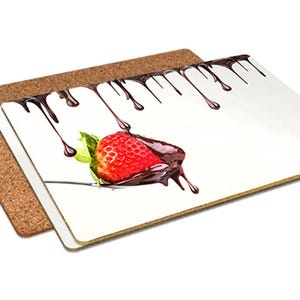 May include: A set of two rectangular coasters. One is a natural cork, the other is white with a graphic of a chocolate-covered strawberry. Dark chocolate drips from the top of the coaster.