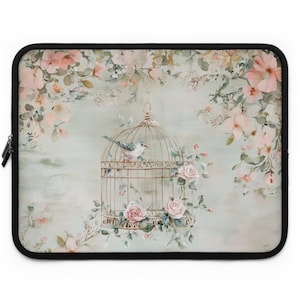 May include: A vintage-inspired laptop sleeve featuring a delicate watercolor painting of a bird in a cage surrounded by pink and white flowers. The background is a soft blue-green color.