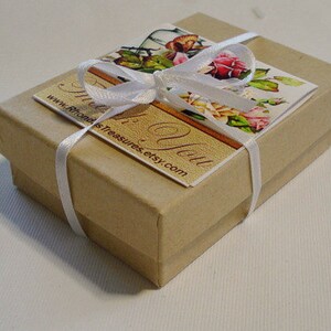 May include: A small, brown cardboard box with a white ribbon tied around it. The box has a label that says "Thank You" and "www.RhondasTreasures.etsy.com".