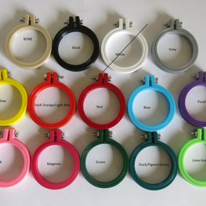 May include: A set of 12 embroidery hoops in various colours, including bone, black, grey, white, yellow, dark orange/light red, red, blue, pink, magenta, green, duck/pigeon green, and lime green.