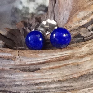 Puede incluir: Un par de pendientes de botón de plata con piedras redondas de lapislázuli azul oscuro.