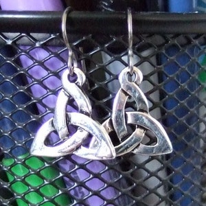 May include: A pair of silver Celtic knot earrings. The earrings are in the shape of a triangle with a knot design.