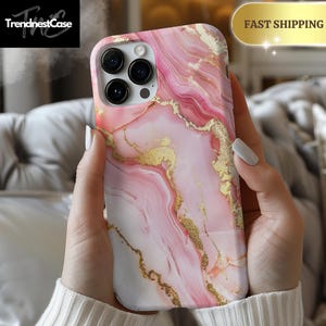 May include: Pink and white marble phone case with gold accents. The case has a camera cutout and is designed for an iPhone.