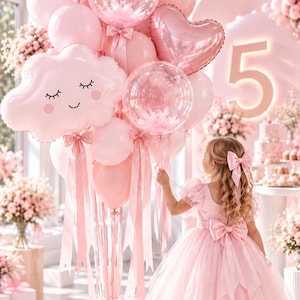 May include: A large cluster of pink balloons featuring heart-shaped foil balloons, clear balloons filled with pink feathers, and two cloud-shaped foil balloons with smiling faces. The balloons are tied with long pink ribbons and satin bows.