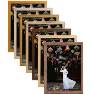 Może przedstawiać: Zestaw sześciu ramek do zdjęć w różnych odcieniach drewna, każda z innym kolorem passe-partout. Ramki są ułożone w sposób schodkowy, z największą ramką na dole i najmniejszą na górze. Wszystkie ramki są puste, ale dolna ramka zawiera zdjęcie kobiety w białej sukience stojącej przed ścianą z kolorowymi lampionami. Zdjęcie zostało zrobione w ciemnym, nastrojowym otoczeniu. Wszystkie ramki są wykonane z drewna i mają prosty, klasyczny design.