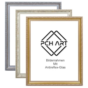 May include: Three picture frames in different sizes and colours: silver, cream, and gold. The frames have ornate details and are made of wood. The gold frame has the text "PCH ART" and "Bilderrahmen Mit Antireflex-Glas" in black.