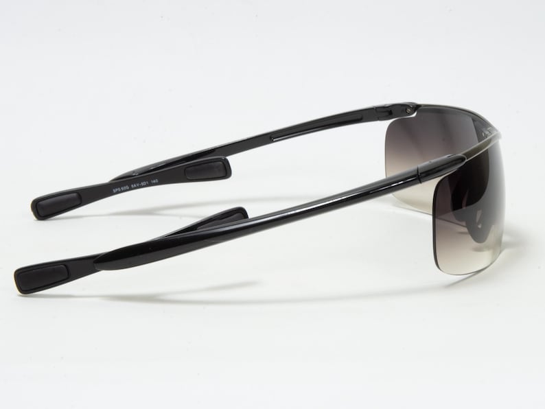 May include: Black sunglasses with a wraparound design. The lenses have a gradient tint, transitioning from dark at the top to lighter at the bottom. The arms are sleek and black, with a curved design for a comfortable fit.