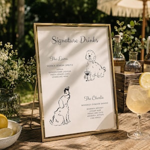 Puede incluir: Un letrero rectangular vertical en un marco de metal dorado titulado Signature Drinks. Enumera The Luna con ingredientes de vodka lemon spritz y The Charlie con ingredientes de whiskey ginger smash, cada uno con un dibujo lineal de un perro.
