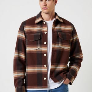 May include: A brown and beige plaid flannel shirt with a button-up front and two chest pockets.