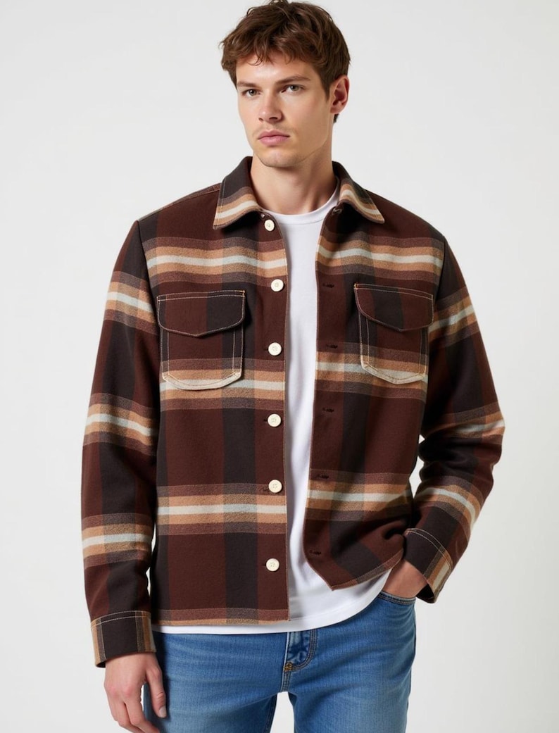 May include: A brown and beige plaid flannel shirt with a button-up front and two chest pockets.