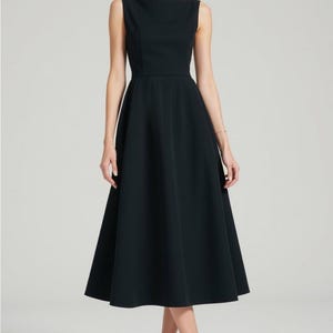 K&ouml;nnte beinhalten: Ein schwarzes, &auml;rmelloses Midikleid mit einem Boot Ausschnitt und einem ausgestellten Rock.