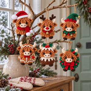 Könnte beinhalten: Sechs gehäkelte Highland-Rinder-Anhänger, die an Zweigen hängen. Die Figuren tragen verschiedene Accessoires: eine Weihnachtsmannmütze mit Schal, ein Rentiergeweih mit roter Nase, eine Elfenmütze, ein Lebkuchenkostüm, einen Puddingaufsatz und einen Kranz.