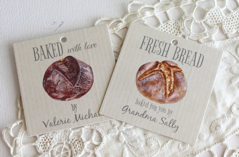 May include: Two brown paper gift tags with images of bread and the text "BAKED with love by Valerie Micha" and "FRESH BREAD baked for you by Grandma Sally".