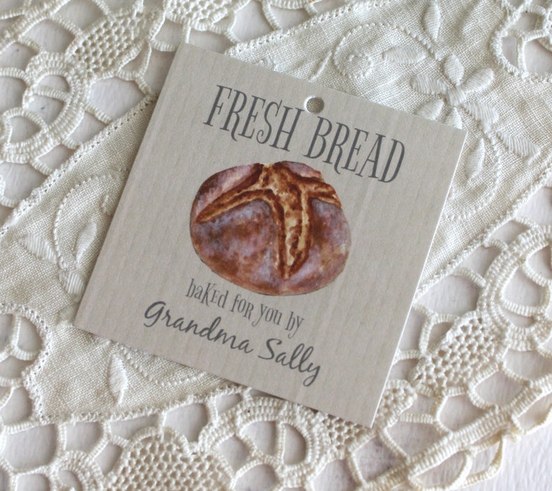 May include: A brown paper gift tag with the text "Fresh Bread" and a drawing of a loaf of bread. The text "baked for you by Grandma Sally" is printed below the bread.