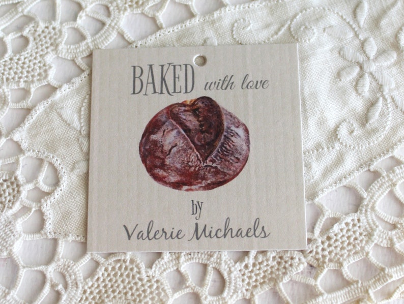 May include: A brown paper gift tag with the text "BAKED with love by Valerie Michaels" and a picture of a loaf of bread.