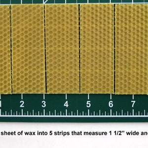May include: Five strips of yellow beeswax foundation sheets, each measuring 1 1/2 inches wide and 4 inches long, are laid out on a green cutting mat with a ruler.