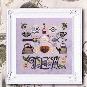 Puede incluir: Un diseño de bordado de punto de cruz con un fondo morado con varios artículos relacionados con el té, incluyendo teteras, tazas de té, limones y un colador de té. La palabra "TEA" está bordada en una fuente decorativa en la parte inferior del diseño.