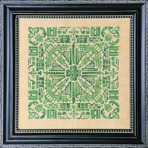 Puede incluir: Una obra de arte en punto de cruz enmarcada con un diseño geométrico simétrico en varios tonos de verde. El diseño está centrado en un fondo beige y enmarcado en un marco negro y ornamentado. La obra de arte muestra puntadas detalladas.