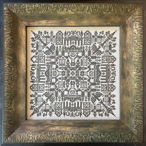 May include: A framed black and white cross-stitch design with a geometric pattern. The frame is a dark brown wood with a gold-coloured finish.