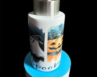 Peut inclure: Distributeur de savon en céramique blanche avec une pompe en acier inoxydable. Le distributeur présente un motif d'Halloween avec un fantôme, une citrouille et le mot "spooky". Il repose sur une base rotative bleue et blanche.