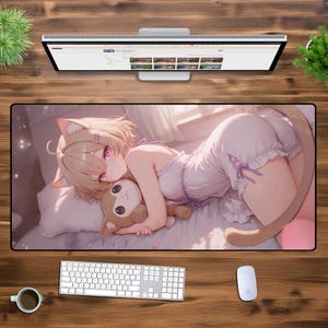 May include: An anime-style mouse mat featuring a girl with blonde hair and a cat tail, wearing a white dress and holding a small plush animal. The background is a soft pink and white.