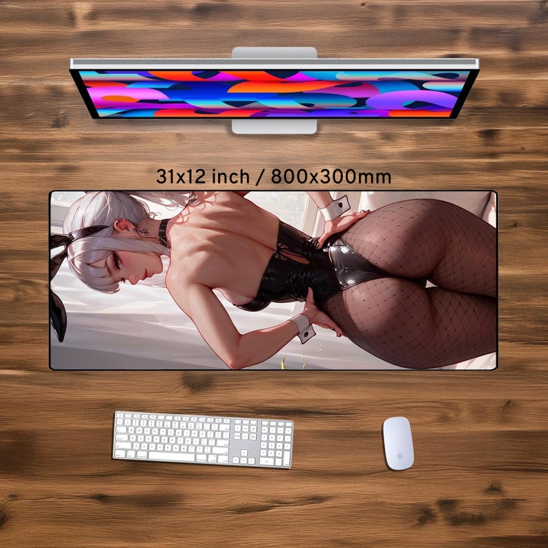 May include: A large rectangular desk mat featuring a detailed illustration of a woman in a black outfit. The mat is 31x12 inches (79x30 cm) and includes a keyboard, mouse, and a computer monitor.