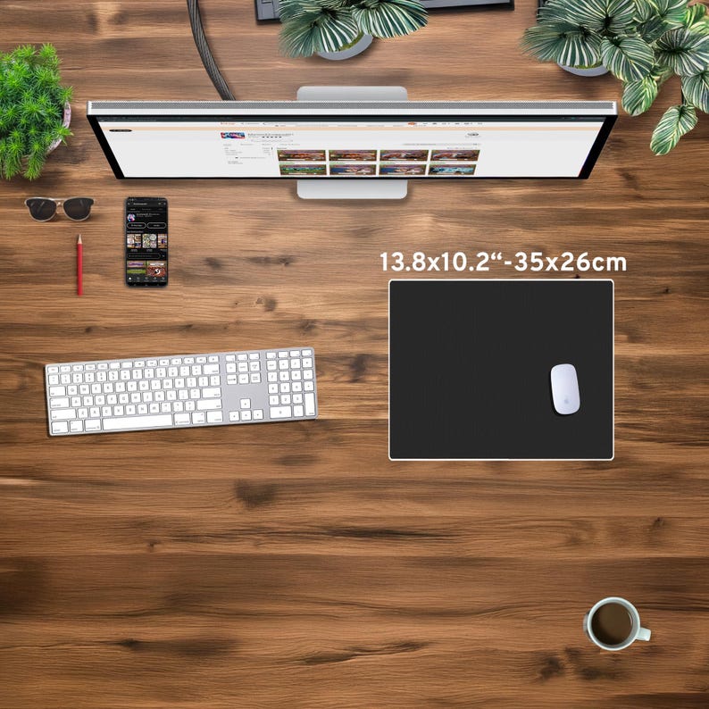 May include: A black rectangular mouse pad, measuring 13.8 x 10.2 inches (35 x 26 cm), with a white mouse on the right side. The pad is on a wooden desk, alongside a keyboard, monitor, phone, and coffee cup.