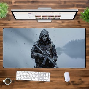 May include: A hooded figure in a dark gray tactical suit holds a black rifle with a scope. The figure is standing in front of a blurry background of a lake and trees. The image is in a dark, moody style.