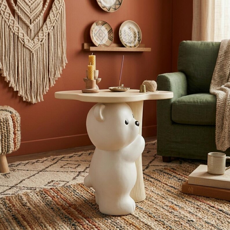 May include: A whimsical, off-white side table featuring a bear-shaped base supporting a light-colored, tree-shaped tabletop. The table is placed on a patterned rug, with a green armchair and decorative items in the background. The table is approximately 24 inches tall.