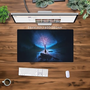 May include: A dark blue mouse mat featuring a fantasy scene of a glowing tree in a forest with a person standing in the foreground. The mouse mat is 60x35cm.