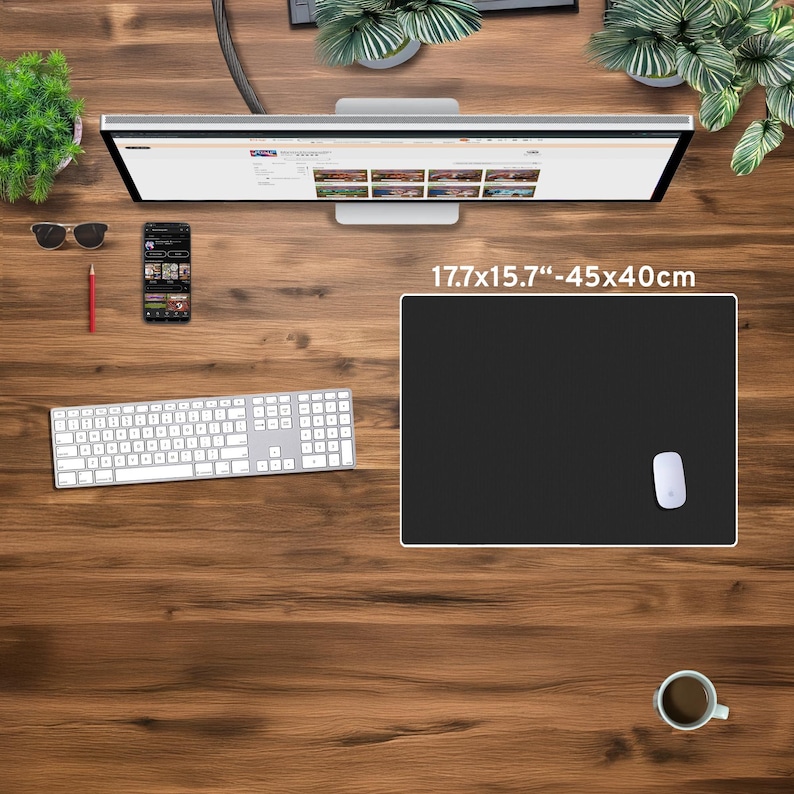 May include: A black rectangular mouse pad, measuring 17.7 x 15.7 inches, with a white border and a white mouse. The pad is on a wooden desk, along with a keyboard, monitor, and a cup of coffee.