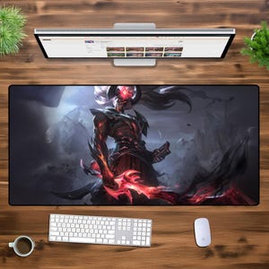 May include: A black and red gaming mouse mat featuring a fantasy character with horns and a red glowing sword. The character is standing on a dark, rocky terrain.