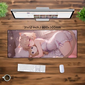 May include: A pink and white anime-style mouse mat featuring a girl with long blonde hair and pink eyes, wearing a white nightgown and holding a small plush animal. The mouse mat is 31x12 inches or 800x300mm.
