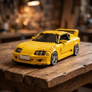 May include: A bright yellow toy sports car made of interlocking plastic bricks. The model car has a spoiler, detailed headlights, and silver-colored wheels. It is sitting on a wooden surface.