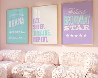 May include: A room with three framed posters and a set of pink modular sofas. The posters have text that reads "Drama, Singing, Dancing", "Eat, Sleep, Theatre, Repeat", and "Future Broadway Star". The sofas are made of a textured, light pink fabric.