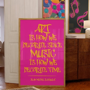 May include: A framed pink poster with the quote "ART IS HOW WE DECORATE SPACE. MUSIC IS HOW WE DECORATE TIME." by Jean Michel Basquiat. Two other framed art pieces are visible, one with vinyl records and another with musical notes.