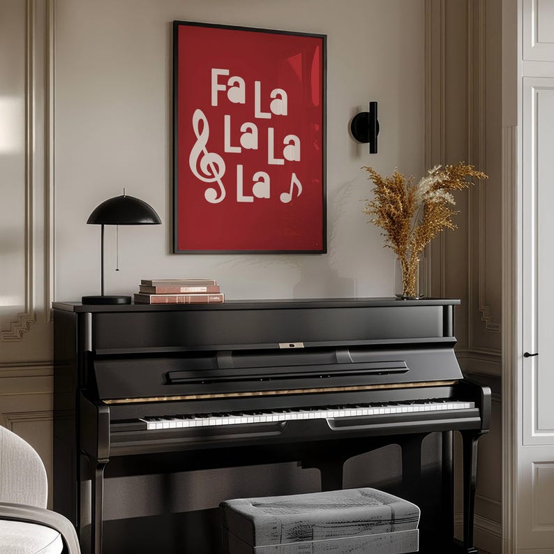 May include: A black grand piano with a red framed print above it that says "Fa La La La La" with a treble clef and a musical note. The print is hanging on a white wall.